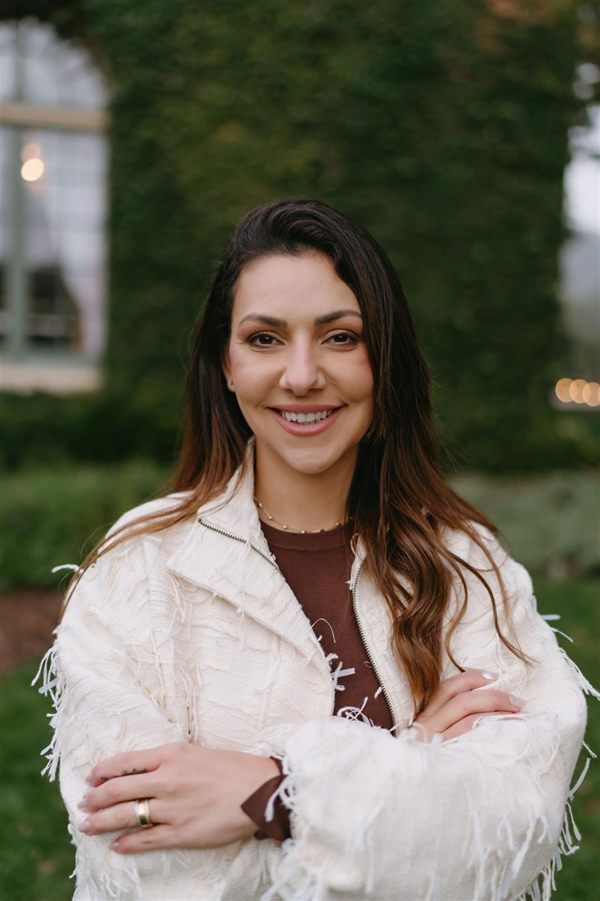 Jhennifer Guimarães, founder of Rhema Cleaning Service, smiling outdoors